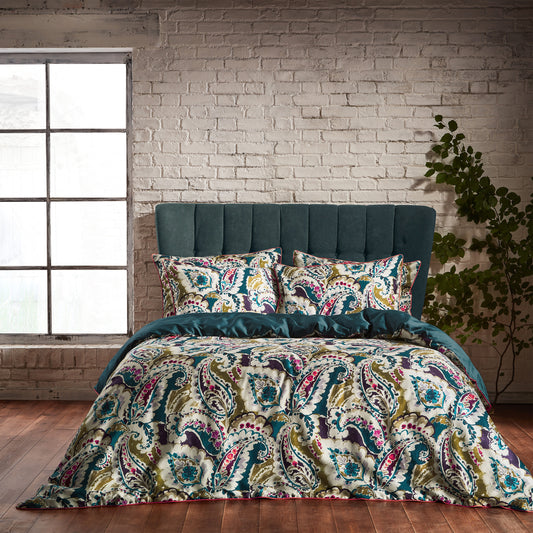 Luxury Aretha Paisley Pattern Duvet Cover Bed set with a dark green headboard and rustic tiled back wall