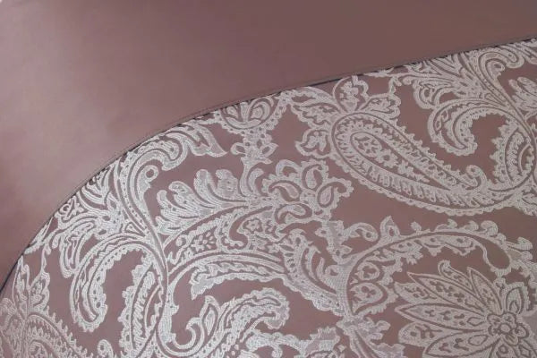 Close up displaying the Duchess Collection Embellished Jacquard Duvet Double Bedding Cover Set in Blush Pink. Gentle paisley pattern in white embroidery.